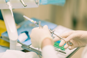 Detail of a dentist performing surgery with anesthesia on a patient for root canal treatment and regeneration. No people are recognizable. - 727125326