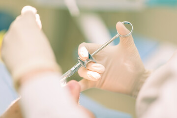 Detail of a dentist performing surgery with anesthesia on a patient for root canal treatment and regeneration. No people are recognizable. - obrazy, fototapety, plakaty