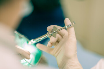 Detail of a dentist performing surgery with anestethics on a patient for root canal treatment and...