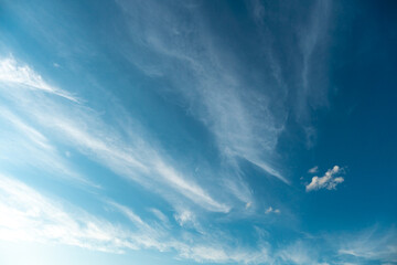 White fluffy clouds in the sky. Blue sky and cloud cover on a sunny summer day. Empty background,...