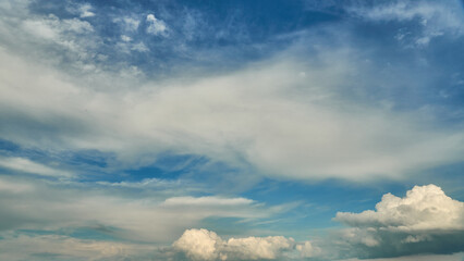 Fluffy orange clouds illuminated by the light coming from the setting sun. Pure nature untouched by man. Climate change from human activity.