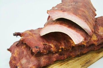 Meat dish smoked ribs on a wooden board. The product is ready to use. White background.