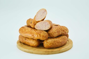Meat dish sausages on a wooden board. The product is ready to use. White background.