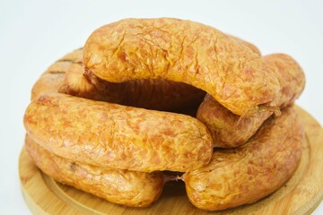 Meat dish sausages on a wooden board. The product is ready to use. White background.