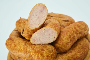 Meat dish sausages on a wooden board. The product is ready to use. White background.