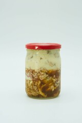 Stewed meat in a glass jar, canned. The product is ready to use. White background.