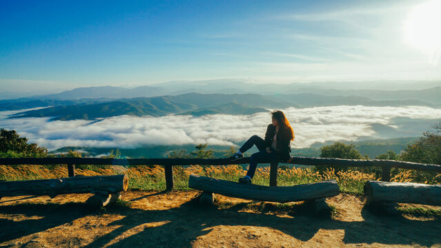 Soft focus of asian women relaxing with fog at Doi Samer Dao in Nan, Thailand. The Silhouette of women setting in front of the sunrise on the hill with the sea of clouds