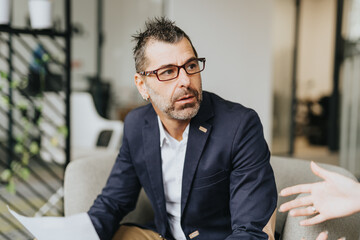 Businessman listening carefully to his partner explaining something. Business people collaborating in an office, analyzing statistics and planning for growth.