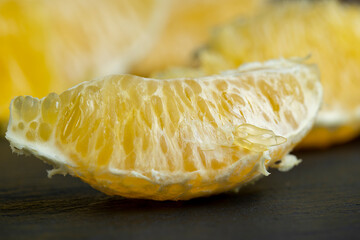 peeled slices of ripe and juicy orange close-up