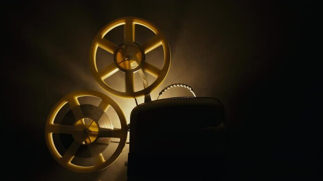Vintage 8mm film projector, rotating reels. Nostalgic charm of classic cinema.