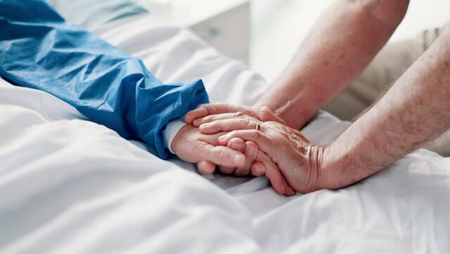 Patient, person and hand holding on hospital bed for support or empathy for health hope, diagnosis or virus. People, fingers and embrace together for wellness grief or marriage, compassion or care