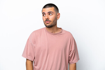 Fototapeta premium Young caucasian man isolated on white background making doubts gesture looking side