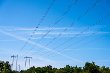 High voltage power lines passing over a forest.