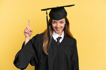 Young university graduate isolated on yellow background pointing up a great idea