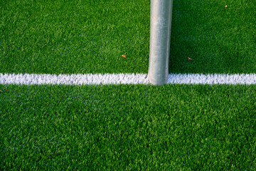 White markings and goal post of an artificial turf football field.