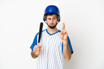 Young caucasian man playing baseball isolated on white background with fingers crossing and wishing the best