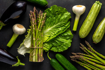 View of fresh asparagus with vegetables on a black table. Food background.