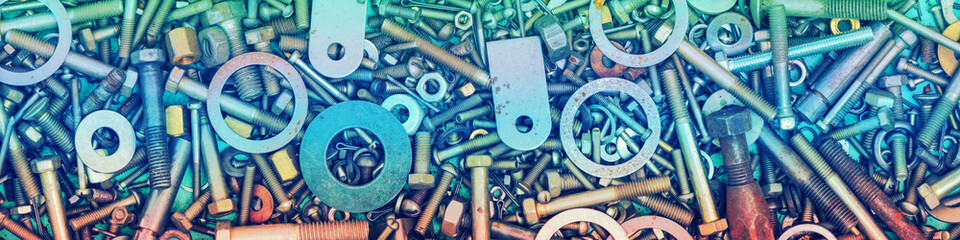 Abstract grunge colorful metal background made of fastening bolts, screws, and nuts. Horizontal...