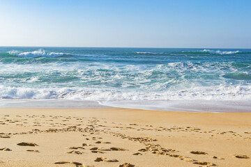 Beautiful ocean waves on a golden sand beach. Alone with nature.