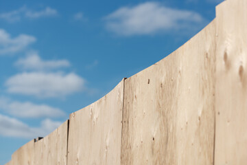 clouds and blue sky with plywood hoarding at a construction site in the city © eugen