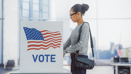 American People on the Election Day in the United States of America. Diverse People Using Voting Booths to Give Their Vote to a Preferred Candidate. Beautiful Black Female Filling Out Her Ballot - obrazy, fototapety, plakaty
