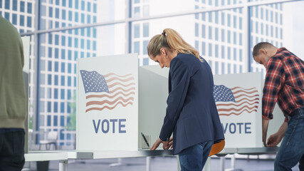 Businesswoman Filling Out a Ballot in a Voting Booth on the Day of National Elections in the United...
