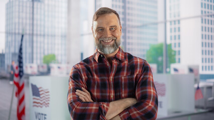 Portrait of a Handsome Caucasian Working Class Man Posing with American Flag in the Background. Successful Adult Masculine Male Smiling, Looking at Camera, Holding Arms Crossed