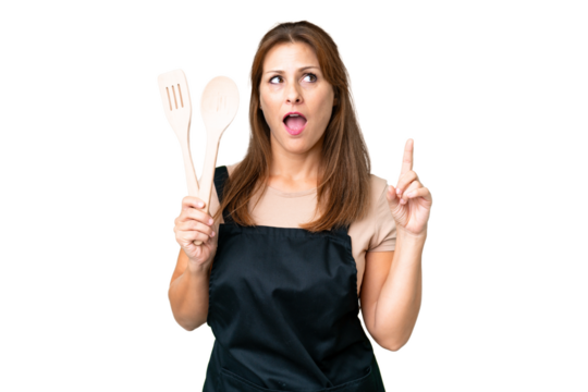 Middle age caucasian woman holding a rolling pin over isolated background thinking an idea pointing the finger up