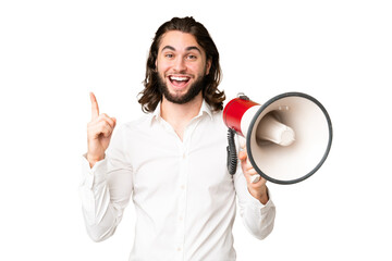 Young handsome man over isolated chroma key background holding a megaphone and pointing up a great...