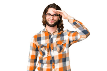 Young handsome man over isolated chroma key background saluting with hand with happy expression