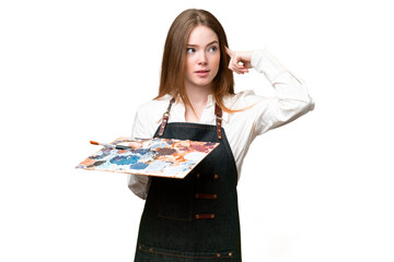 Young artist woman holding a palette over isolated chroma key background having doubts and thinking