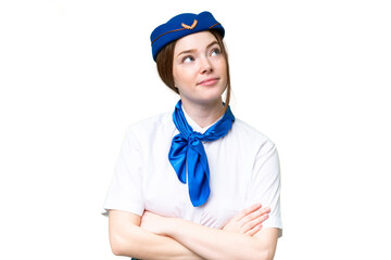 Airplane stewardess over isolated chroma key background looking up while smiling