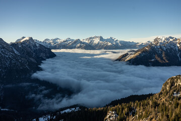 Mountain above clouds, Civetta resort. Panoramic view of the Dolomites mountains in winter, Italy. Ski resort in Dolomites, Italy. Aerial  drone view of ski slopes and mountains in alps.