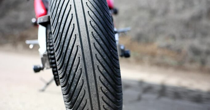 Bald smooth bad rubber motorcycle tire on road. Cross tire pressure and motor tires