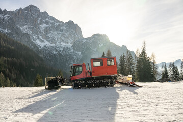 Piste groomer in front of the Mountains Dolomites alps  Italy. Snow groomer in dolomites alps in Italy. snow groomer in winter mountains.