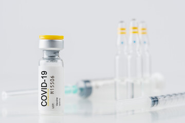 Coronavirus vaccine vial glass with a syringe on white background. Covid-19 medicine vaccination...