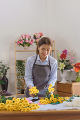 Floristry concept, Woman florist choosing chrysanthemum for making bouquet flora in flower shop