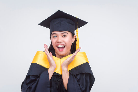 Surprised young woman in graduation attire looking amazed and excited. A graduate of bachelor of science. Isolated on a white background.
