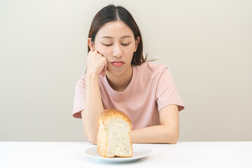 Gluten allergy asian young woman expression face, looking bread refusing to eat on plate in...