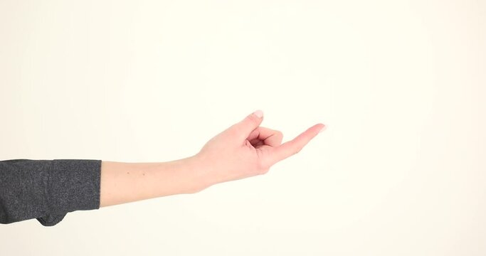 Woman hand beckons with index finger on white background. Woman gesturing with one finger calls and come here symbol