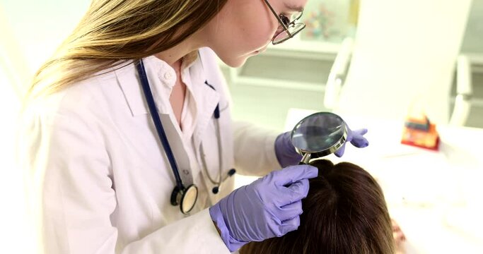 Dermatologist consultation trichologist examines woman hair through magnifying glass. Problem of hair loss in woman