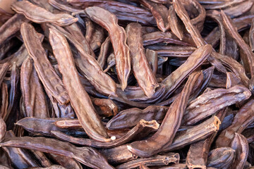 dried carob sold openly in the market,