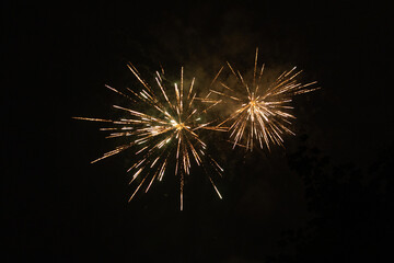 Fototapeta premium Burst of orange fireworks at night - vibrant orange streaks and sparks - smoke clouds - celebration, new years day, fourth of july, canada day. Taken in Toronto, Canada.