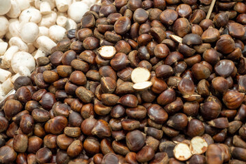Chestnut seller and his stall has a lot of raw chestnuts,