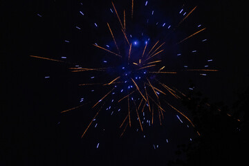 Burst of blue and orange fireworks at night - vibrant streaks and sparks - smoke clouds - celebration, new years day, fourth of july, canada day. Taken in Toronto, Canada.