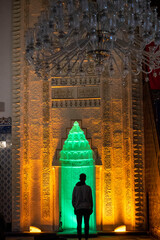 Silhouette shot of a Muslim praying in the Hacı Bayram Veli Mosque, the altar of the mosque and a person praying.