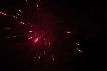 Burst of red fireworks at night - vibrant red streaks and sparks - smoke clouds - celebration, new...