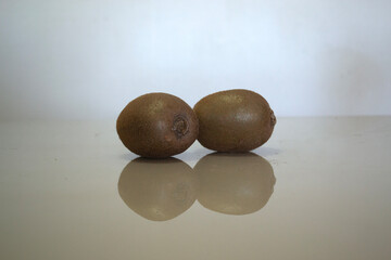 The reflection of some kiwis on a table