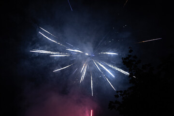 Burst of white fireworks at night - vibrant white streaks and sparks - smoke clouds - celebration,...