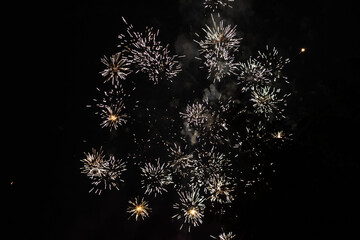 Bursts of white and yellow fireworks at night - vibrant streaks and sparks - smoke clouds -...
